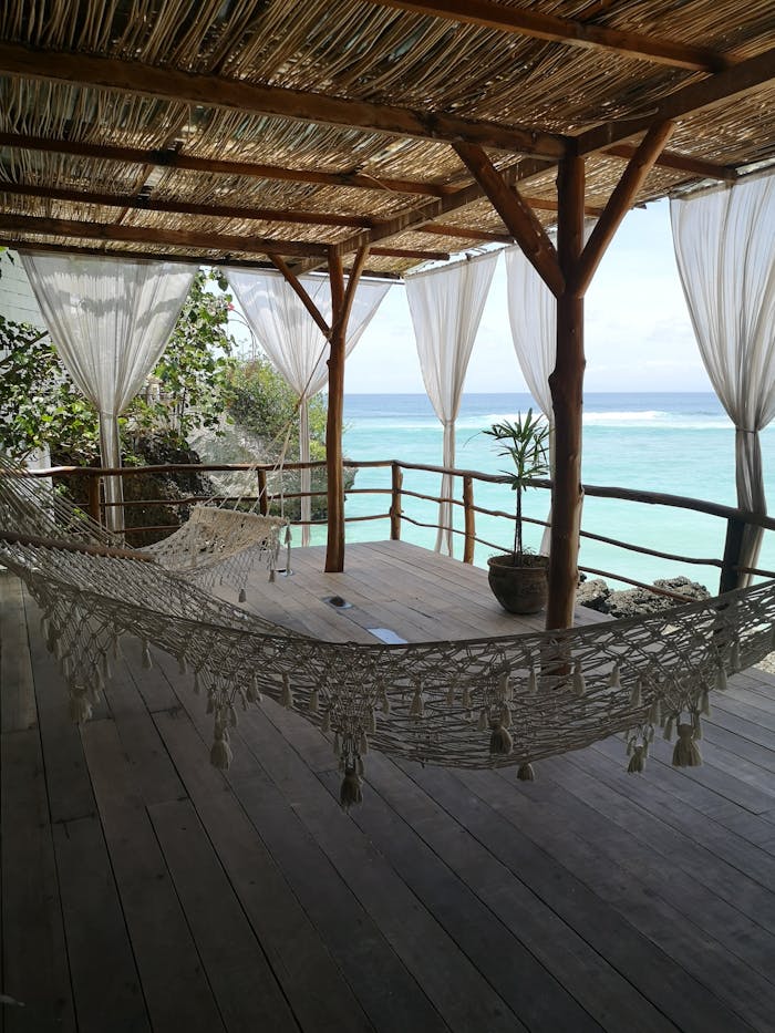 Offerings Serene coastal terrace with hammocks and sea view in South Kuta, Bali.